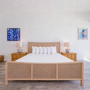 Master bedroom featuring a cozy king bed, stylish lamps, and breathtaking views through expansive windows and balcony doors