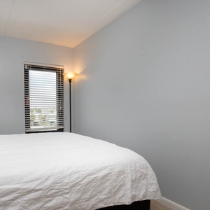The bedroom features a comfortable bed and a window with a view of the surrounding area