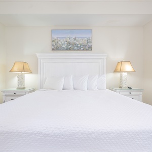 Cozy master bedroom featuring a king bed, elegant lamps, and tasteful artwork for a relaxing retreat