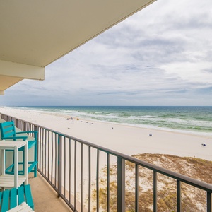 Enjoy relaxing beachfront views from the balcony, featuring bright turquoise seating for relaxation and ocean breezes