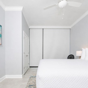 Relax in this serene guest bedroom featuring a king bed, stylish decor, and a large TV for your entertainment