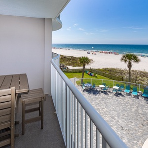 This balcony offers a stunning view with a wooden table and chairs, perfect for relaxing and enjoying the scenery