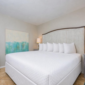 A king bed in the guest suite invites you to sink into restful calm beneath glowing bedside lamps