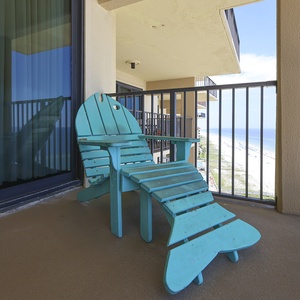 Relax in this vibrant turquoise chair on your private balcony, offering breathtaking views of the sandy beach below
