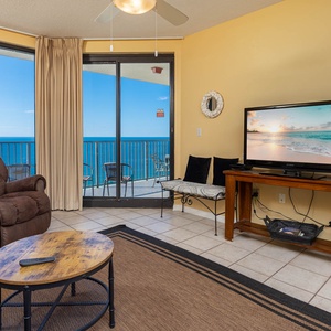 Unwind in the cozy living area with a plush recliner, sofa with queen sleeper, and enjoy beach views through large windows