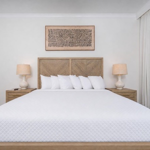 Spacious master bedroom featuring a king bed, stylish decor, and soft lighting from bedside lamps