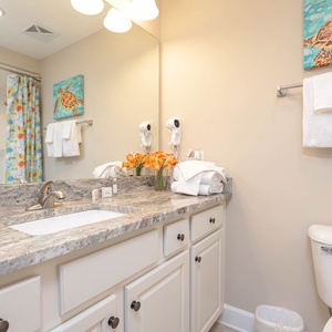 Rejuvenate in the guest bathroom, surrounded by fresh towels and vibrant decor, after a day of adventure