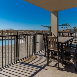 Relax at the outdoor dining set, overlooking the pool and enjoying the refreshing breeze from the beach