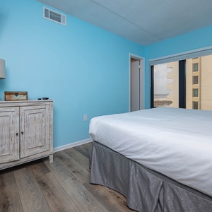 This bedroom features a comfortable bed, stylish decor, and a lovely view through large windows