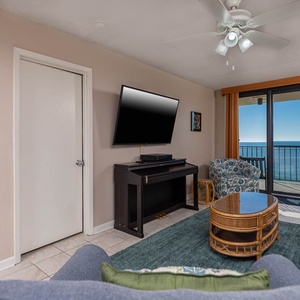 Living room featuring a large TV, cozy seating, and a breathtaking view from the balcony