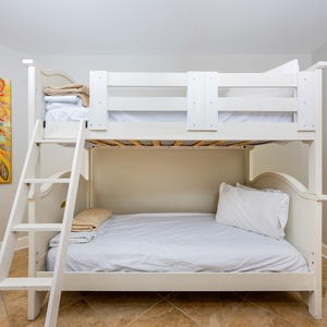 This cozy room features a white twin bunk bed with colorful artwork, perfect for kids to enjoy their stay