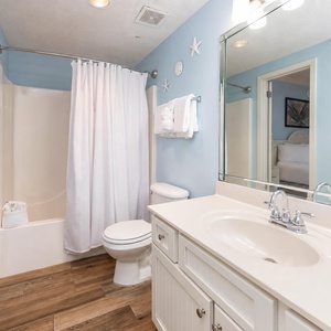 Refresh in the clean bathroom featuring a spacious vanity, soft blue walls, and a shower with a curtain for privacy