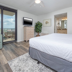 Unwind in this comfortable master bedroom featuring a king bed, stylish decor, and access to a balcony with views