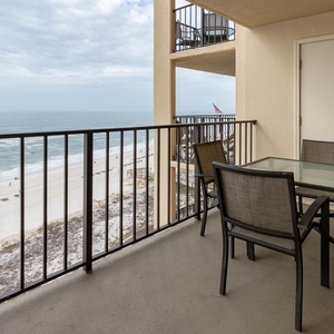 Enjoy a relaxing meal on the balcony with a breathtaking view of the serene beach and gentle waves below