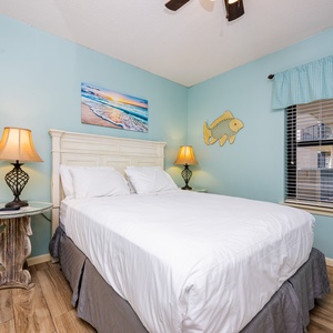 Rest comfortably in the inviting guest bedroom with a queen bed, charming decor, and natural light from the window