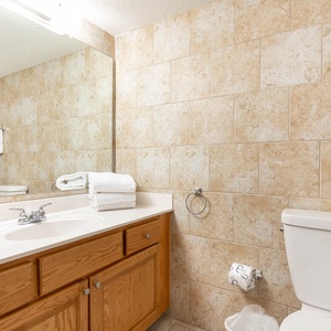Refreshing guest bathroom featuring a spacious countertop, soft towels, and a refreshing shower area