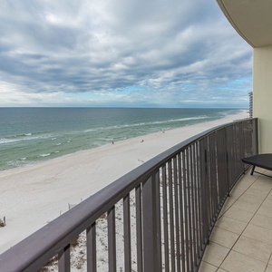 Bask in the fresh air from your balcony, featuring a lounge chair and views of the beach and gentle waves