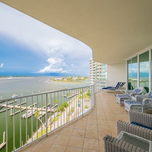 Spacious balcony with comfortable seating and enjoy the serene waterfront views and vibrant blue skies