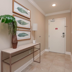 Step into a serene entryway adorned with lush greenery, inviting you to unwind and begin your beach vacation