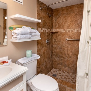 This bathroom features a stylish shower with elegant tile accents, fresh towels, and a relaxing coastal vibe