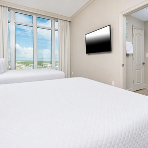 Rejuvenate in the queen guest bedroom, where soft bedding invites relaxation and views create a peaceful atmosphere