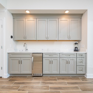 Pour your favorite drink from this wet bar with elegant cabinetry and a stylish design