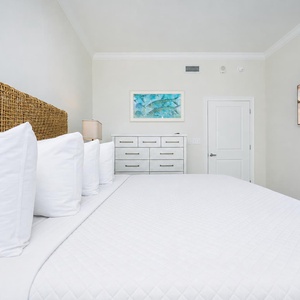 Experience comfort in this serene guest bedroom with a king bed, soft linens, and a large TV