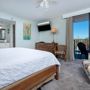 The master features a comfortable king bed, a flat-screen TV, and a lovely view from the balcony