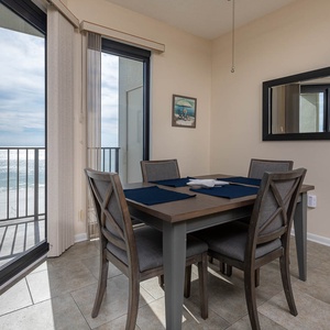 Dining area featuring a table with seating for four and a stunning view of the gulf through large sliding glass doors