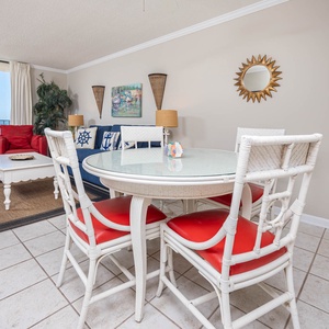 Enjoy meals at the round dining table, surrounded by vibrant seating and a beachfront view