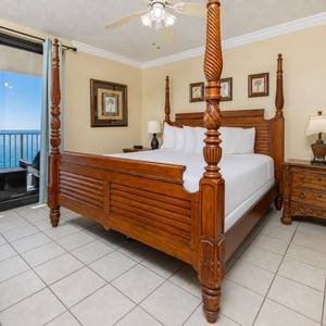 Retreat to this inviting master bedroom featuring a king bed, elegant decor, and a balcony with beachfront views