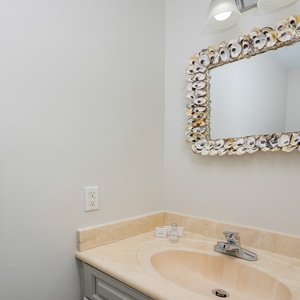 Additional half bath featuring a shell-framed mirror and soft towels for your comfort