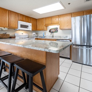 Kitchen features light wood cabinetry, granite countertops, and a breakfast bar with four black stools for casual dining