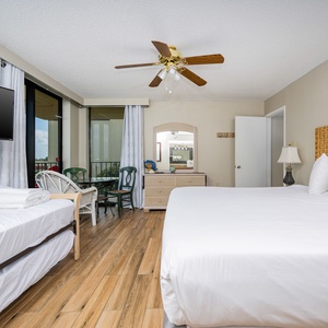 The master features a king bed, a twin with twin trundle, a TV, and a cozy seating area with a view through large windows