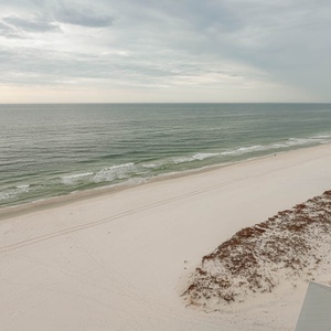 This stunning beachfront view showcases soft white sand and gentle waves, perfect for relaxation and enjoyment