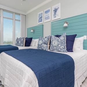 Wake to stunning sights in this queen guest suite with two cozy beds and coastal views from the windows