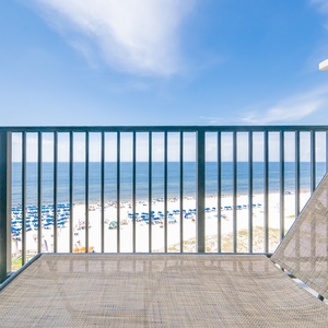 Relax on the balcony lounge chair with breathtaking views of the beach and tranquil blue waters