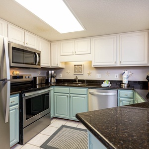 The cabinetry complements the dark countertops in this kitchen, featuring a convenient breakfast bar and coffee station