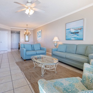 Unwind in the comfortable living area with soft seating, sofa with queen sleeper, stylish coffee table, and coastal decor