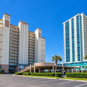 Experience a welcoming beachfront retreat at Royal Palms in Gulf Shores with palm trees and convenient on-site parking