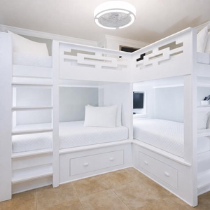 This bunk bedroom features two unique full bunk beds with storage underneath and TV's for entertainment