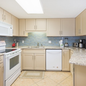 Enjoy cooking in this kitchen, featuring granite counters, white appliances, and a stylish backsplash