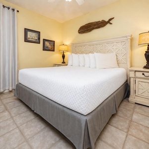 Rest comfortably in this inviting bedroom featuring a plush king bed, soft lighting, and charming coastal decor