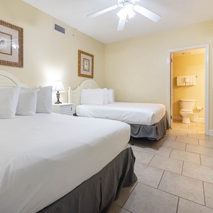 Rest in the inviting guest bedroom featuring two comfortable double beds, soft linens, and warm decor for a restful stay