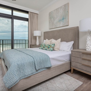 This bedroom features a serene view with a balcony, plush bedding, and a stylish lamp, perfect for relaxation