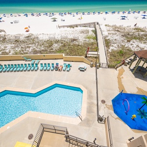 Sunlight sparkles on the pool as you hear children laughing near the playful splash area by the coast