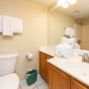 The guest bath featuring a spacious countertop, neatly stacked towels, and a tub/shower combo for a refreshing experience