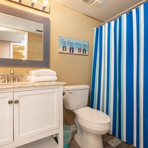 Colorful guest bathroom with a stylish striped shower curtain, modern vanity, and plush towels for a refreshing stay