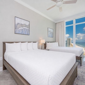 Awaken to a beautiful beach sunrise in this queen guest suite with two cozy beds and get ready for a beach day