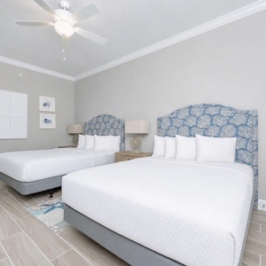 Cozy guest bedroom featuring two comfortable queen beds, soft linens, and coastal-inspired decor